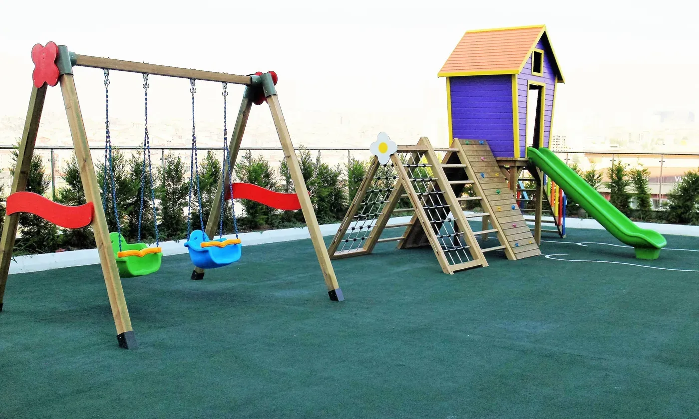 Anaokulu bahçesinde ahşap salıncak