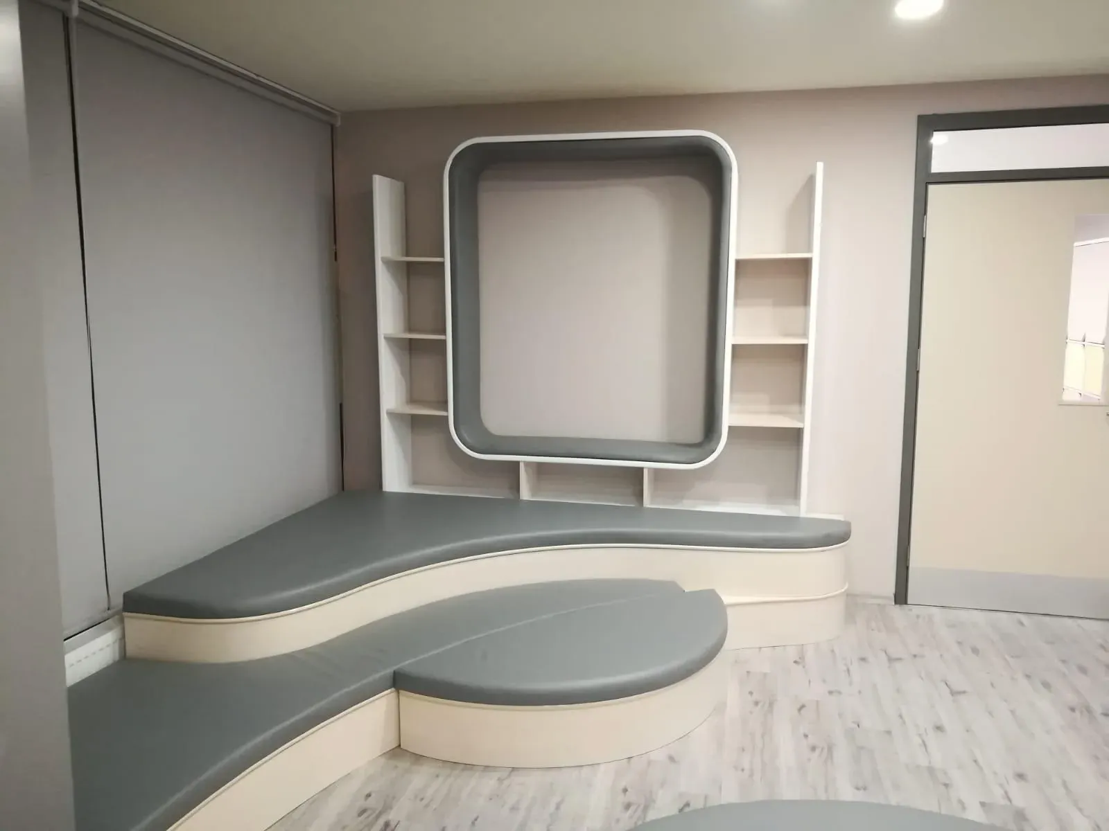 Duvara gömülü raf sistemi ve kavisli minderli pencere oturma ünitesi